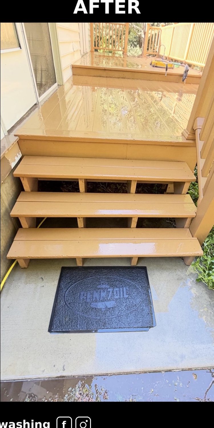 The same deck stairs after washing, boards wet and the concrete clean